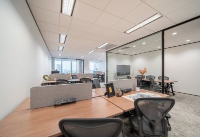 Open-plan workspace with multiple wooden desks and ergonomic chairs.