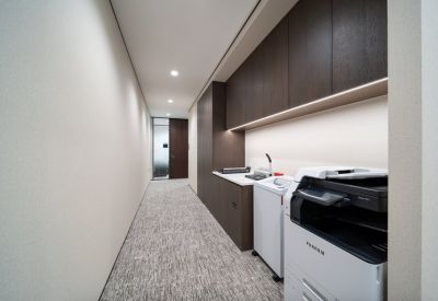 Minimalist office corridor with integrated storage and printing station.