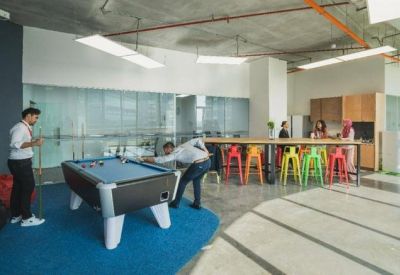Communal breakout space featuring a pool table and colorful bar stools.