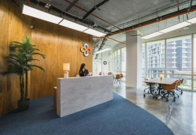 Reception area with wood-paneled walls, a marble desk, and a branded wall logo.