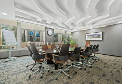 Large boardroom featuring a long oval table, leather chairs, and a wavy ceiling design.