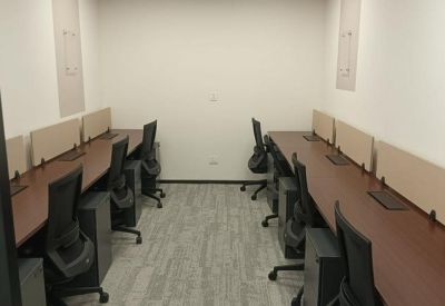 Compact private office suite with two rows of desks and grey chairs.