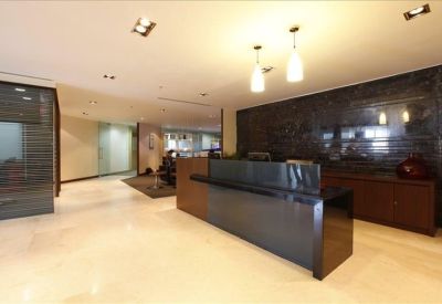 Reception area with a dark polished desk and a textured feature wall.