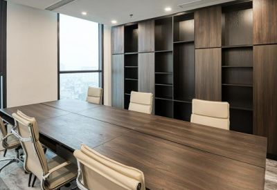 Spacious boardroom with a long wooden table and built-in dark wood shelving unit.