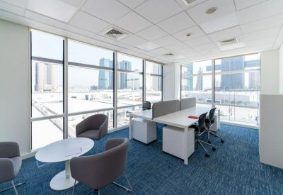 Bright corner office with modern desks and floor-to-ceiling windows.