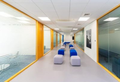 Long bright corridor with colorful modular seating pods.