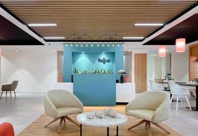 Modern reception area with teal feature wall and comfortable seating.