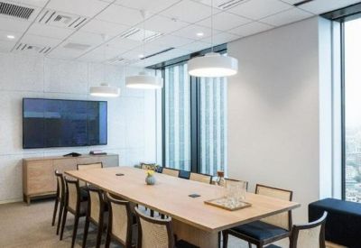 Bright meeting room with a light wood table and large windows overlooking the city.