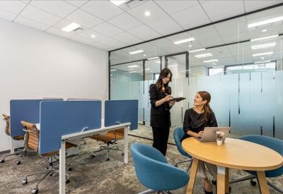 Modern breakout area with blue privacy screens and a small round meeting table.
