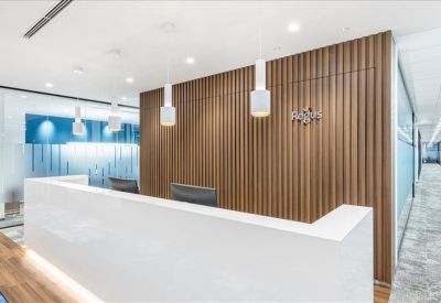 Elegant reception area with a minimalist white desk and vertical wood-slat wall.