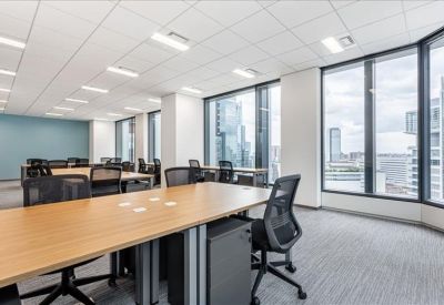 Spacious open-plan workspace with wooden desks and expansive city views.