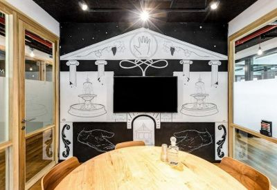 Meeting room with a round wooden table and a distinctive black and white mural.