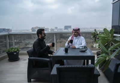 Outdoor terrace with comfortable seating and a city skyline backdrop.