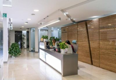 Professional reception area with a long illuminated desk and warm wood paneling.