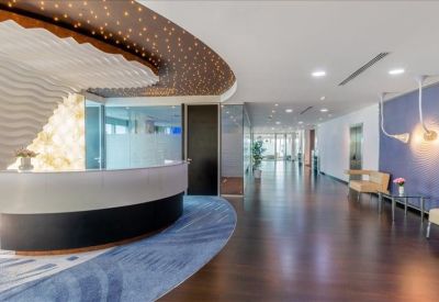 Sleek modern reception area with a curved white desk and creative ceiling design.