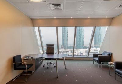 Modern private office with a desk and city views through floor-to-ceiling windows.