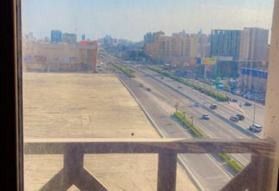 City view overlooking a highway and urban landscape from a decorative balcony railing.