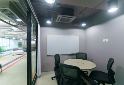 Small private meeting room with a round table, four chairs, and a whiteboard.