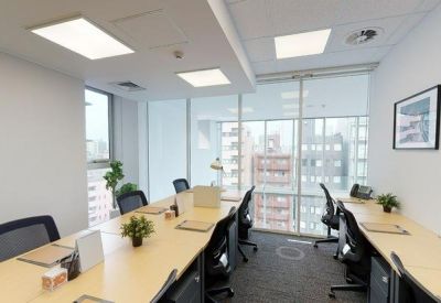 Bright conference room with a long wooden table, black mesh chairs, and framed artwork.