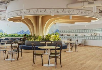 Meeting area centered around a unique wood pillar structure with circular booth seating and plants.