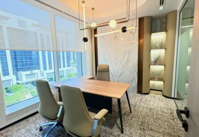 Executive private office with a wooden desk, plush seating, and modern pendant lighting.
