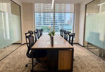 Large conference table in a bright room with panoramic city views through floor-to-ceiling windows.