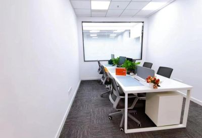 Bright four-person private office with white desks and mesh chairs.