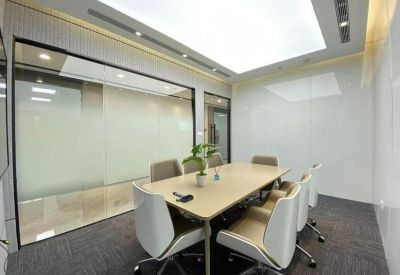 Professional meeting room featuring a light wood table and white executive chairs.
