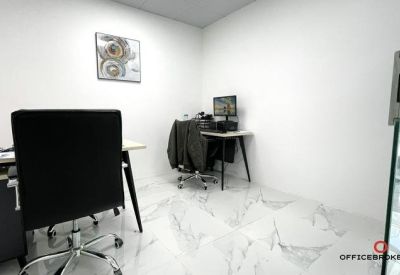 Workspace featuring a black office chair and a desk with a secondary monitor setup.