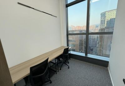 Private office featuring a long wooden desk positioned against a window overlooking the city.