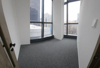 Empty private office suite featuring grey carpeting and floor-to-ceiling city views.