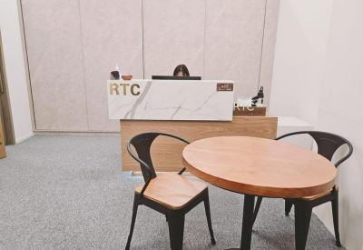 Sleek marble reception desk with the RTC logo and a nearby round meeting table.