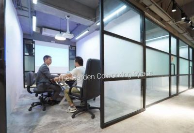 Four-person meeting room with frosted glass partitions and a wall-mounted projector screen.