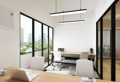 Bright private office suite featuring a wooden desk and large floor-to-ceiling windows.