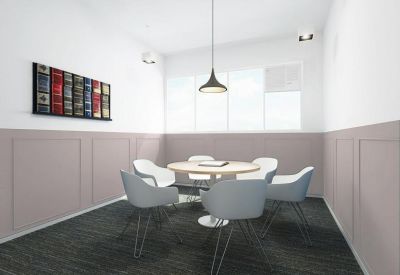 Small meeting room with a round table, white chairs, and decorative wall art.