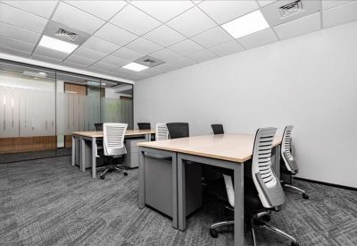 Spacious office area featuring multiple workstations and white walls.