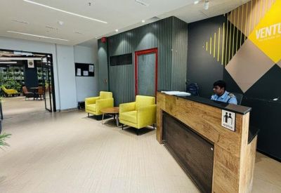 Reception desk with wooden panelling and bright yellow armchairs.