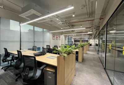 Open-plan workspace with wooden desks and integrated planters.