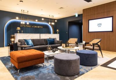Branded reception area featuring a velvet sofa, marble desk, and warm ambient lighting.