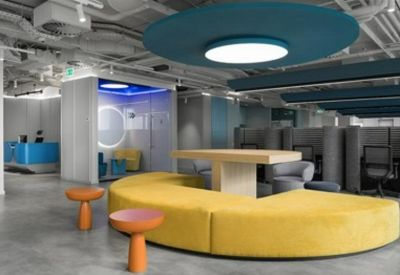 Vibrant communal lounge with a yellow semi-circular sofa and teal ceiling features.