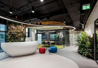 Bright reception area featuring a curved white desk and living green wall.