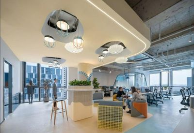 Sunlit open-plan office with creative lighting fixtures and collaborative seating.