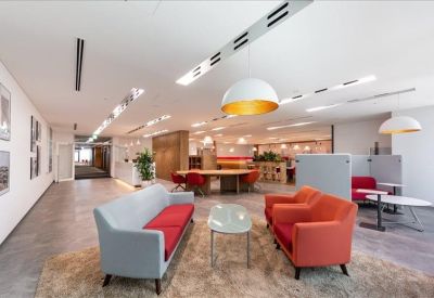 Lounge area with grey and orange sofas, a plush rug, and large dome pendant lights.