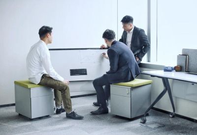 Collaborative office space with team members working at a whiteboard.