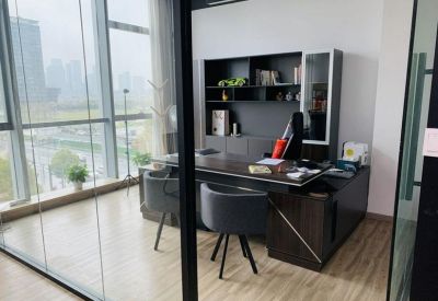 Private executive office with a dark wood desk, ergonomic chairs, and large floor-to-ceiling windows.