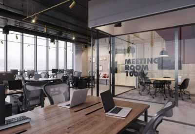 Industrial-style workspace featuring a glass-enclosed meeting room and wooden desks.