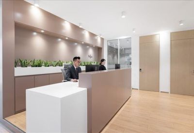 Modern reception area with a wood-toned desk and built-in planters.