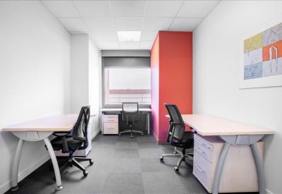 Private three-person office suite with a pink accent wall and large window.