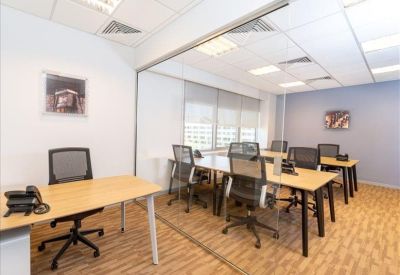 Spacious open-plan office with glass partitions and multiple workstations.