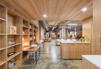 Spacious communal kitchen and breakout area with light wood cabinetry and shelving.